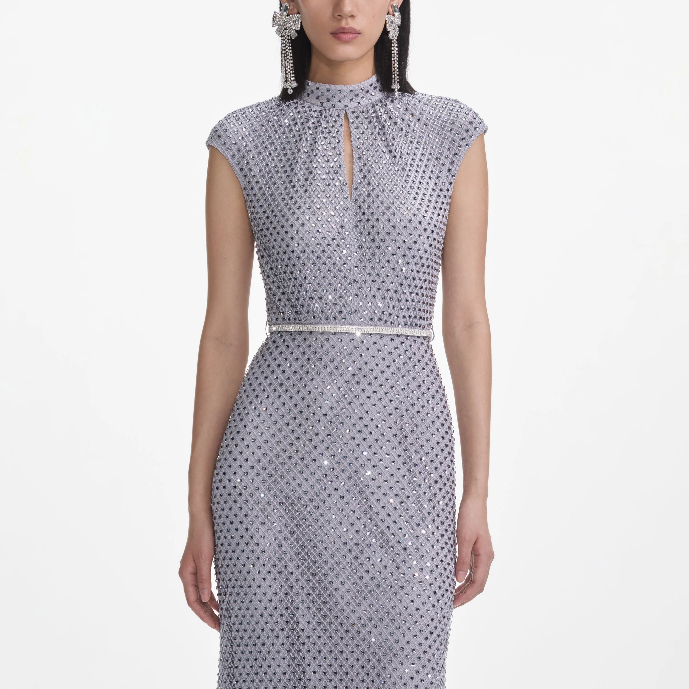Woman wearing a silver sequin dress on a white background